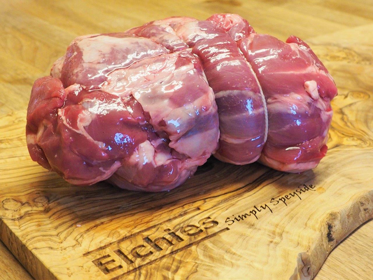 A portion of rolled and boned goat meat on an Elchies branded wooden board.