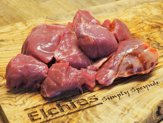 A portion of diced goat leg meat displayed on a branded Elchies wooden board. 